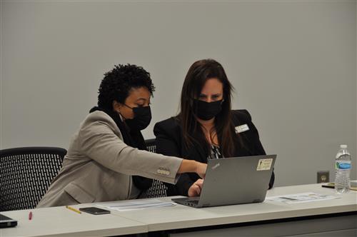 Two GCPS administrators working with a laptop