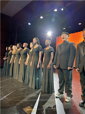 10 swtudents standing on a stage singing