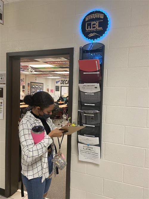 Students checking out to leave for work at the WBL station outside of Rainge's classroom