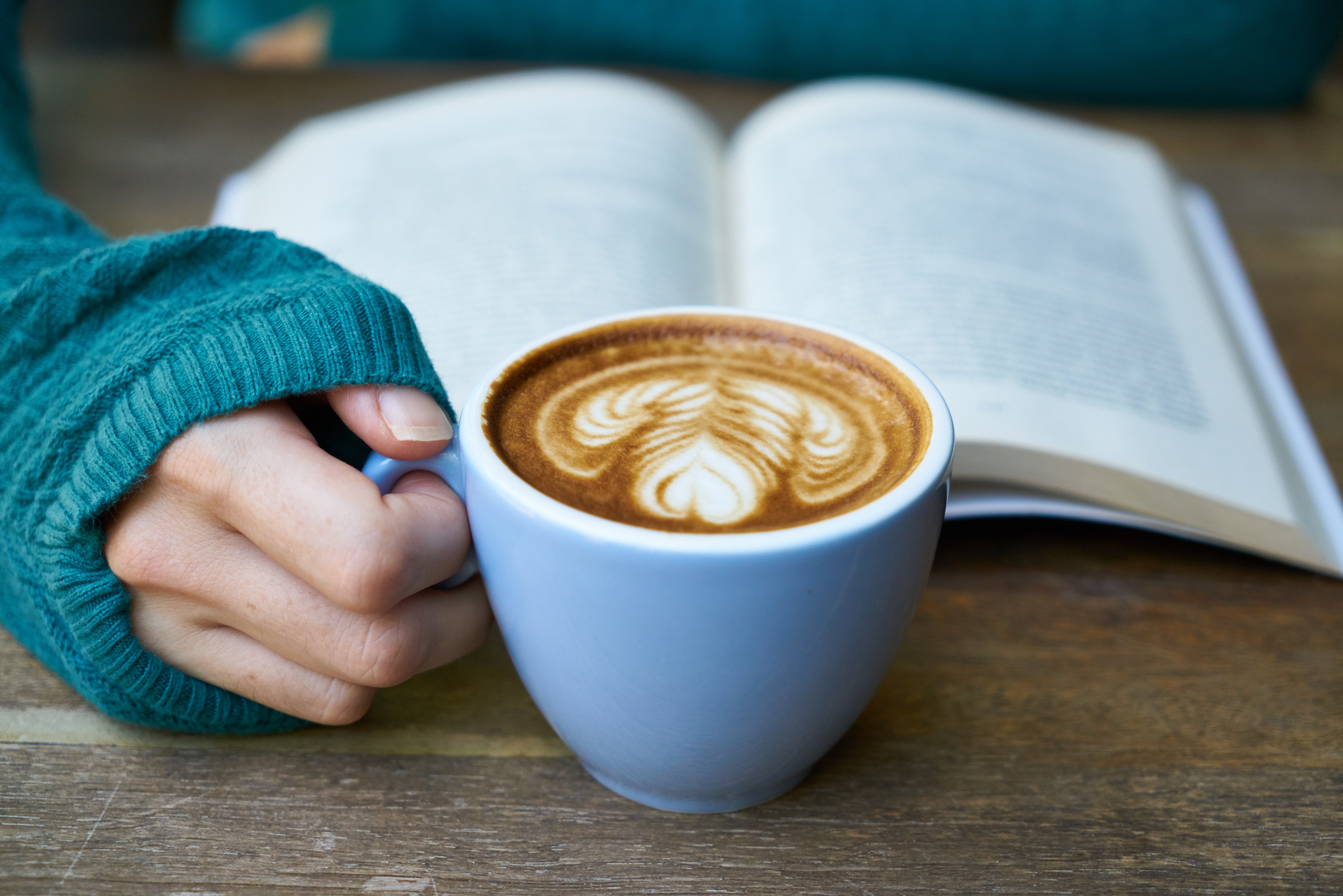 Student reading a book and drinking coffee 